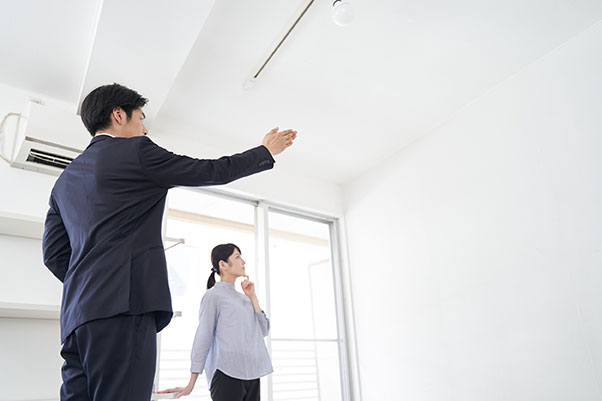 Agent immobilier salarié présentant un appartement lumineux à une cliente