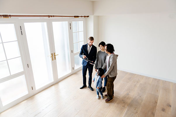 Agent immobilier salarié, présentant un appartement lumineux à un couple avec un enfant